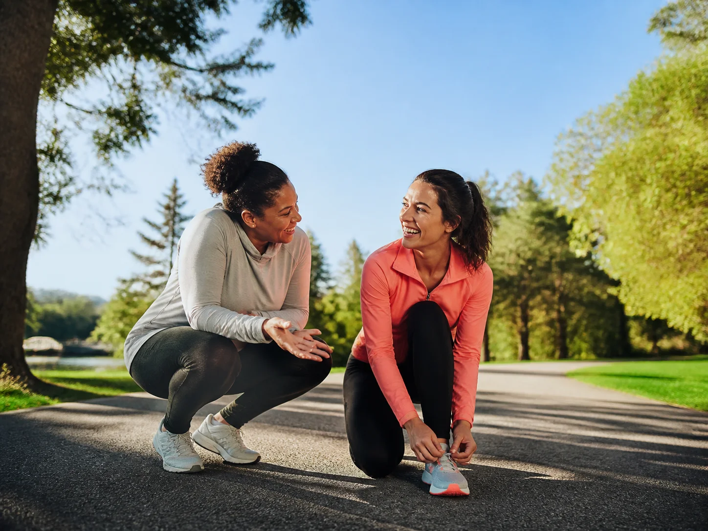 Two friends encouraging each other before a sunny park run